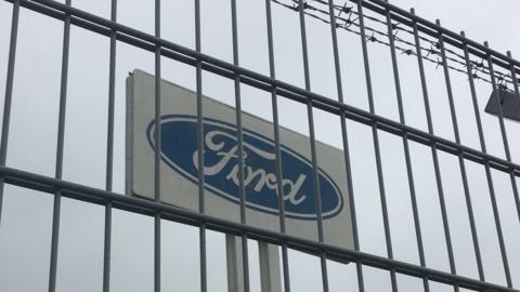 Ford sign behind a fence with barbed wire
