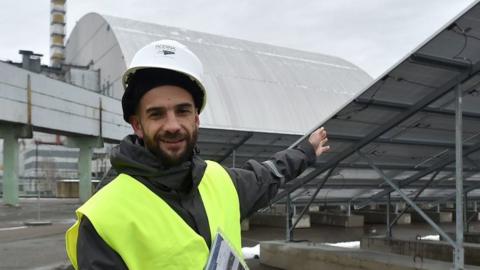 worker standing in front of solar plant