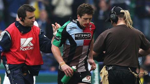 Tom Williams of Harlequins walks off with physio Steph Brennan to be replaced by team mate Nick Evans (not in picture) as blood pours from his mouth during the Heineken Cup Quarter Final match between Harlequins and Leinster at the Stoop