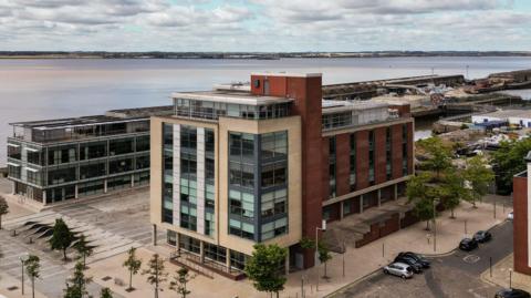 A drone shot of Two Humber Quays - a modern building by the Humber Estuary and the Marina.