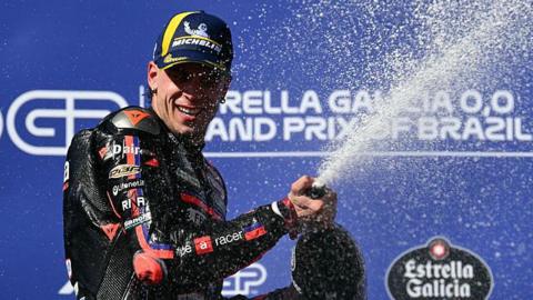 Italy's Marco Bezzecchi's sprays champagne on top of the podium after his victory in the MotoGP