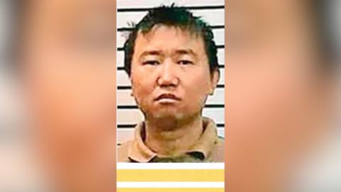 A mugshot of man with short dark hair