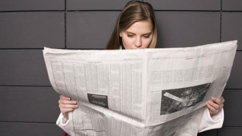 woman reading a paper