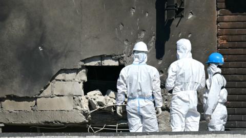 Forensic investigators examine the location of impact after a Russian drone struck an apartment building in Galati, eastern Romania