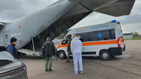 The ambulance being loaded into the plane