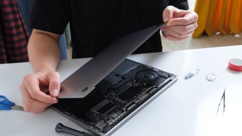 A man disassembles a laptop. stock photo