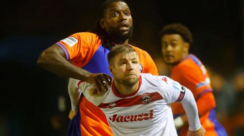 Jay Emmanuel-Thomas battles with Connor Riley-Lowe of Truro City