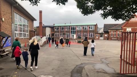 Parents taking their children to school