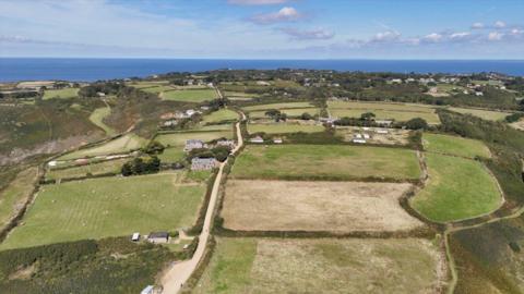 Aerial view of the island of Sark. The image shows farmland and fark tracks with several properties dotted around the land.