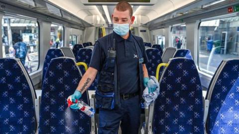 A railway worker cleans a carriage