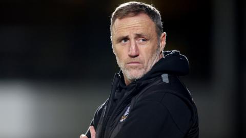 Port Vale boss Andy Crosby watches on during a game