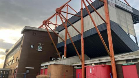 The rear of Inverness Caledonian Thistle's stadium in Inverness. There is steelwork supporting the main stand.