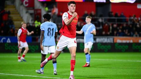 Josh Ayres celebrates with a clenched fist after scoring Rotherham's second goal against Manchester City