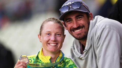 Alyssa Healy poses with her 2022 Commonwealth Games medal alongside husband Mitchell Starc