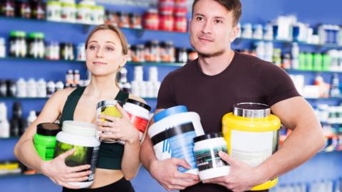 Man and woman holding protein powder 