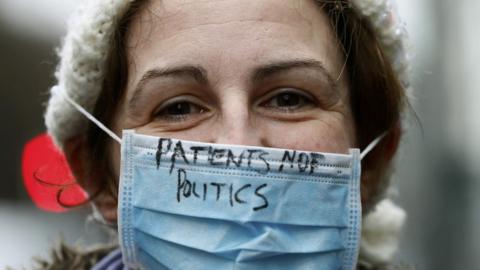 Junior doctor with slogan on her mask