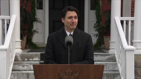 Justin Trudeau stands in front of a wooden podium.