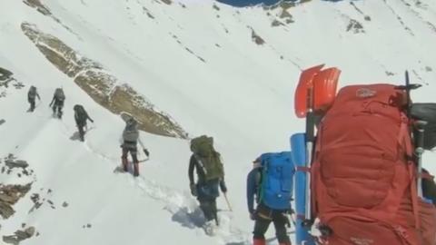 The video shows climbers slowly making their way to the Nanda Devi peak