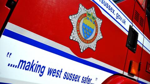 The West Sussex Fire & Rescue Service web address on a red fire engine with a quote saying "... making west sussex safer..."