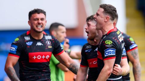 Wigan players celebrate Jack Farrimond scoring against St Helens