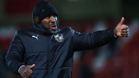 Port Vale manager Darren Moore gives a thumbs up to the crowd