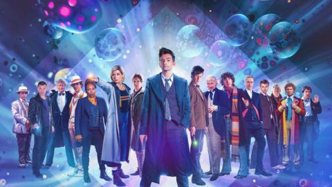 Every incarnation of the Doctor standing in a line, with David Tennant as the 14th Doctor at the head, flanked by Jodi Whittaker and Matt Smith.