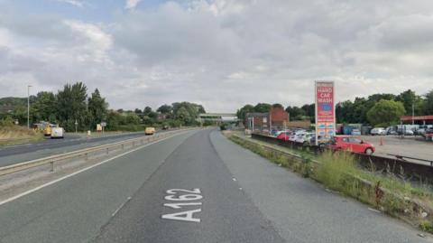 A sign for a car wash at the side of a dual carriageway.