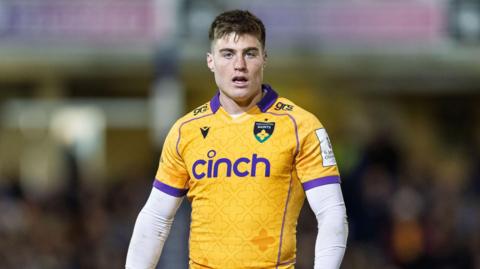 Tommy Freeman standing on the pitch with his arms by his sides during a game for Northampton Saints