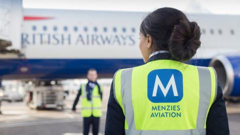 Ground handling staff in front of aeroplane