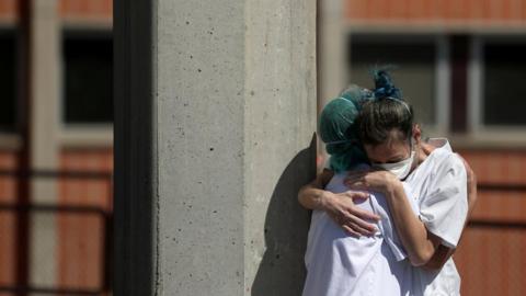 Medical wokers hug eachother outside the emergency rooms at Severo Ochoa Hospital during the coronavirus disease in Spain