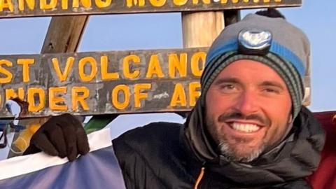 Joshua Mitchell at the top of Mt Kilimanjaro