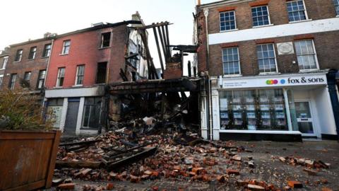 A general view of the scene of the fire, on December 09, 2024 in Dorchester, England, with bricks spilling out into the street. 