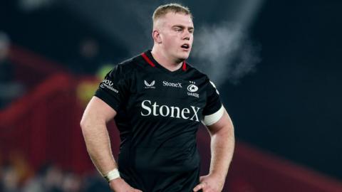 Phil Brantinghamv standing on the pitch with his hands on his hips wearing Saracens kit