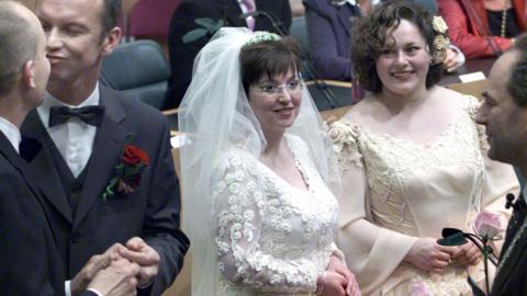 Dolf Pasker and Gert Kasteel kiss each other after getting married just after midnight by Amsterdam's mayor Job Cohen as Helene Faasen and Anne Marie Thus wait to get married in Amsterdam, early on April 1, 2001.