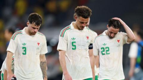 Ethan Ampadu leads Wales off after defeat by Romania