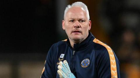 Brian Jensen in his Shrewsbury Town track top taking a warm-up session before a game