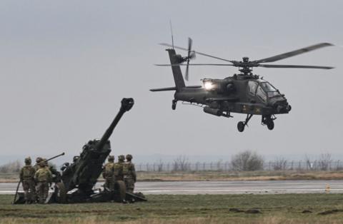 An Apache helicopter takes off during a demonstration on a military base