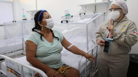 A health worker assists a Covid-19 patient at the Gilberto Novaes Municipal Hospital in Manaus, Brazil