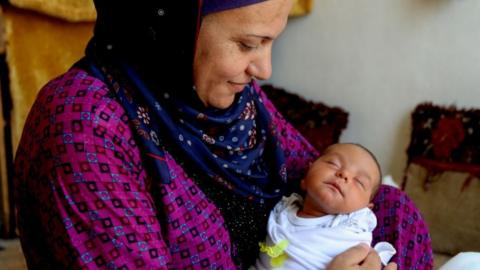 A Syrian refugee holds her newborn girl in Beirut