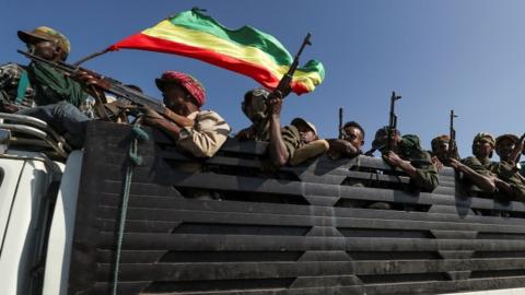 Members of Amhara region militias ride on their truck as they head to face the Tigray People"s Liberation Front (TPLF),