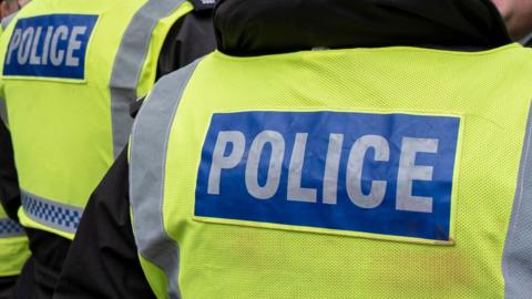 The back of two high-vis police vests