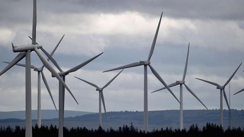 wind turbines in a field with hills in the background