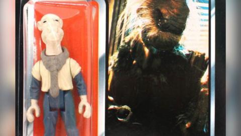 A Yak Face toy figurine, with a price tag on, showing a cream figure, wearing blue trousers and top, and an image of him from the Star Wars film, next to the figurine.