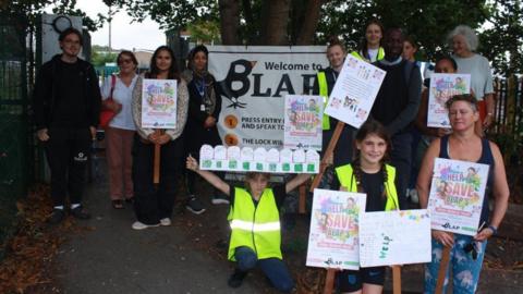 Campaigners raising awareness for the playground holding signs.