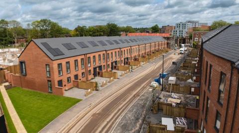Row of two-storey homes with pitched roofs on a new development 