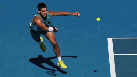 Carlos Alcaraz runs to reach a forehand
