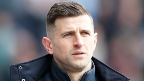 Portsmouth boss John Mousinho watching his side from the touchline as they face Preston at Deepdale