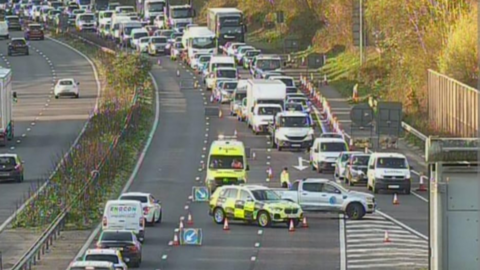 A congested motorway with police vehicles at the scene. 