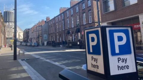A 'pay here' sign in a street in Liverpool city centre.