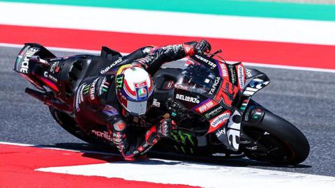 Marco Bezzecchi leans low to his right as he takes a corner